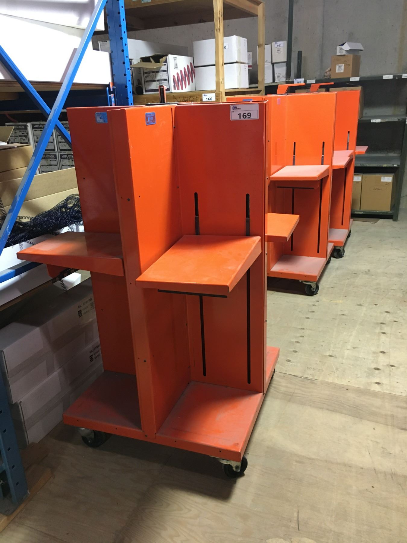 GROUP OF 3 ORANGE METAL ROLLING QUADRACART KANSA-SPRING LOADED SHELVES