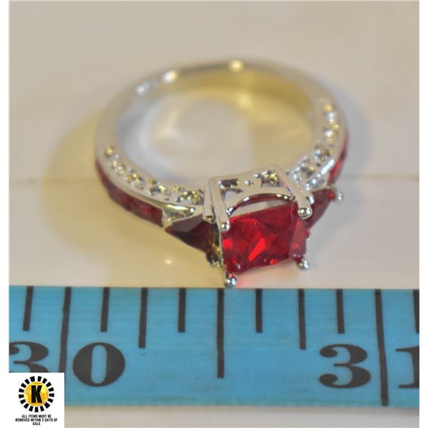 LADIES RING WITH RUBY COLORED STONES