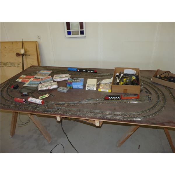 Train track set up on 4 by 8 sheet of plywood with various accessories