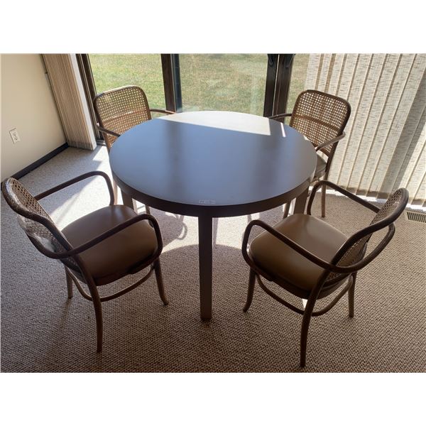 Round Beige Dining Table With Four Wooden-Framed Rattan Chairs