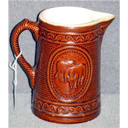 BROWN STONEWARE COW DECORATED PITCHER, 8 " HIGH