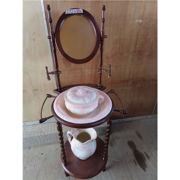 Antique wooden washing station with pitcher and bowl and mirror.