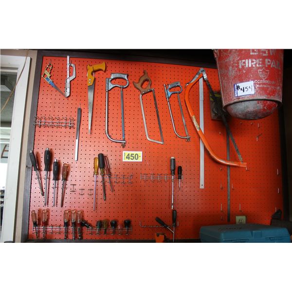 Hack saws, screwdrivers etc. on peg board