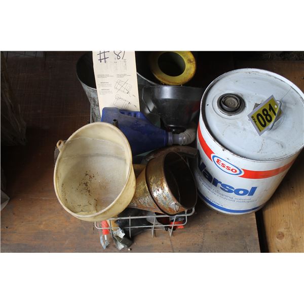 Partial pail of varsol and funnels.