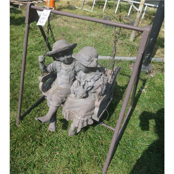 Cute decorative lawn ornament of boy & girl sitting on a swinging on a chair (31.5”x 36”)
