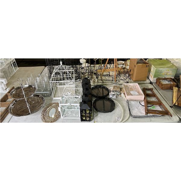 Table top full of assorted wedding decor - bird cages/ candle lanterns/ picture frames etc.