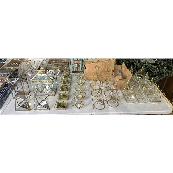 Large table of assorted decor pieces including - candle holders, fake terrarium, glass decor, etc...