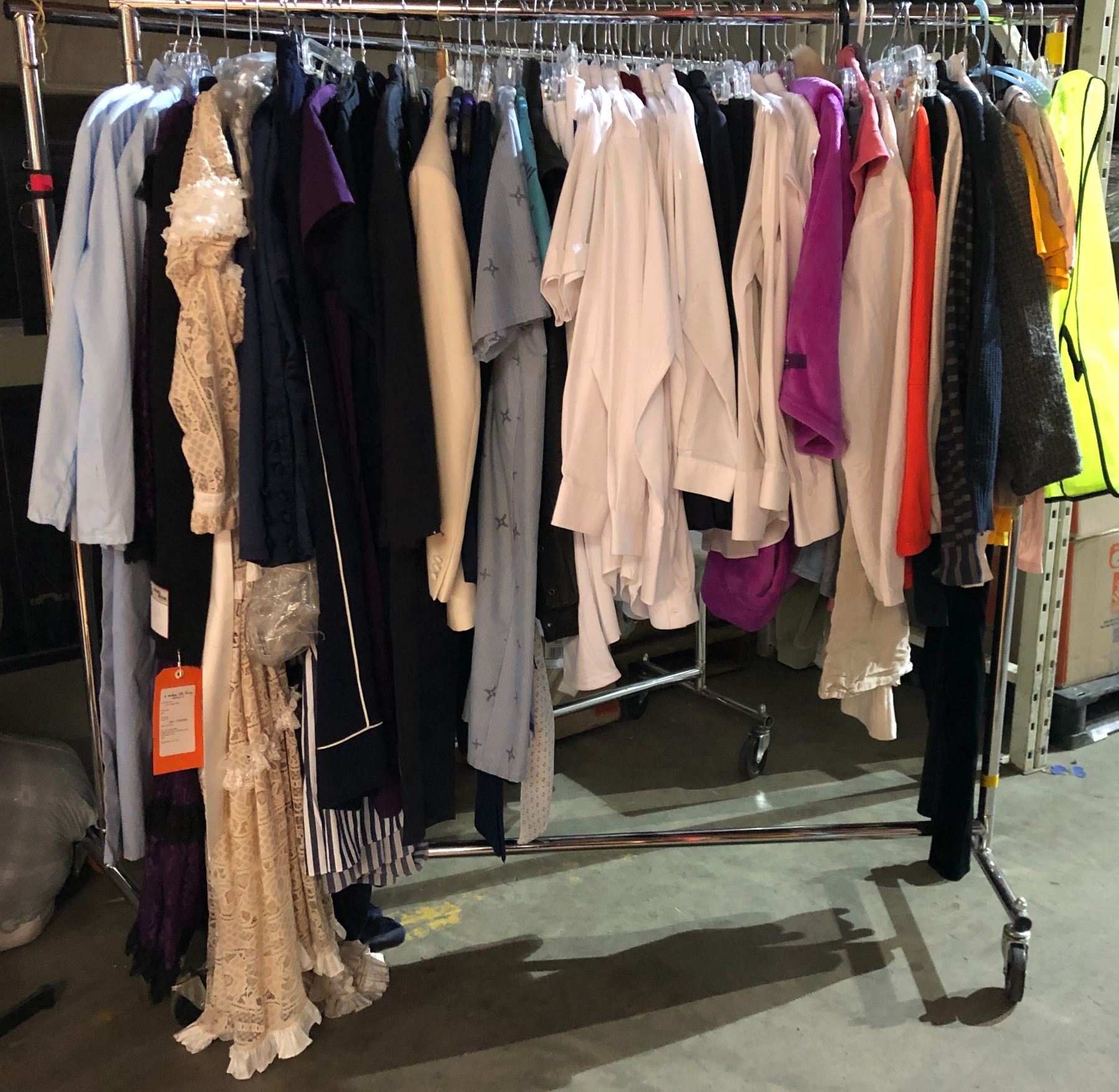Rack lot full of assorted clothes - includes safety vests / white dress ...