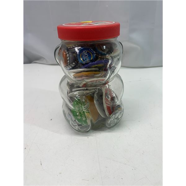 Peanut butter jar filled with pin backs and bottle lids