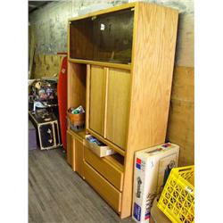 Wooden entertainment center with glass doors and video storage area; box of various cassette tapes; 