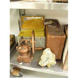 Old metal coffee grinder; piece of soapstone; make-up case with celluloid tray; old walrus hide suit
