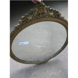 Ornate gold frame oval mirror.