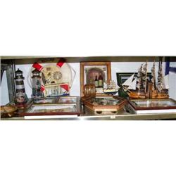 Shelf of nautical items and framed items: clock, ship bookends, ship in a bottle, lighthouses, life 