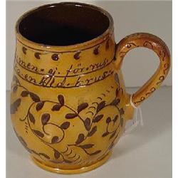 A PENNSYLVANIA DUTCH REDWARE PRESENTATION DRINKING MUG