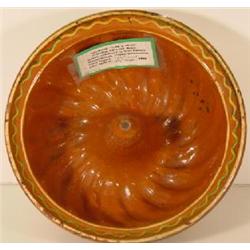A PENNSYLVANIA REDWARE "TURK'S HEAD" PUDDING OR CAKE MOLD