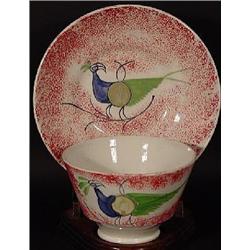 "PEACOCK RED SPATTERWARE HANDLE-LESS TEA CUP AND SAUCER