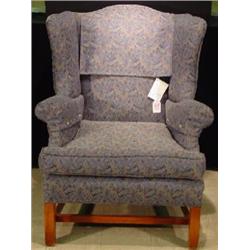 AN UPHOLSTERED WING-BACK ARMCHAIR