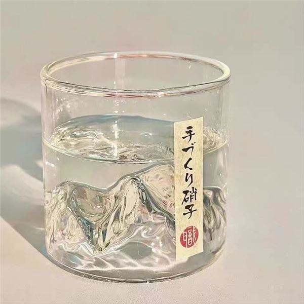 Whisky glass, snow-capped mountain