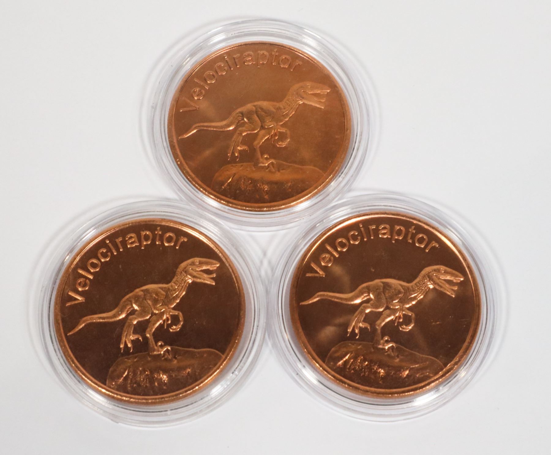 THREE VELOCIRAPTOR COPPER ROUNDS IN CAPSULES
