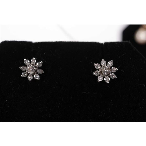 Pair of 14kt white gold and diamond solitaire studs each surrounded by eight point diamond enhancers