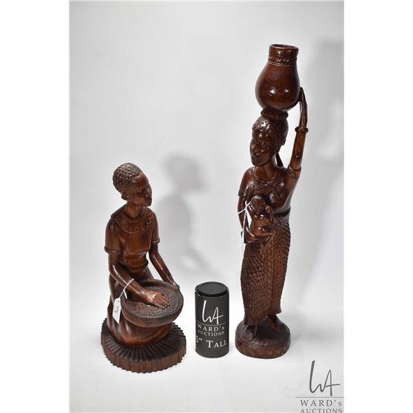 Two carved wooden figures including woman w/ two children measuring 23" high and woman w/ basket mea