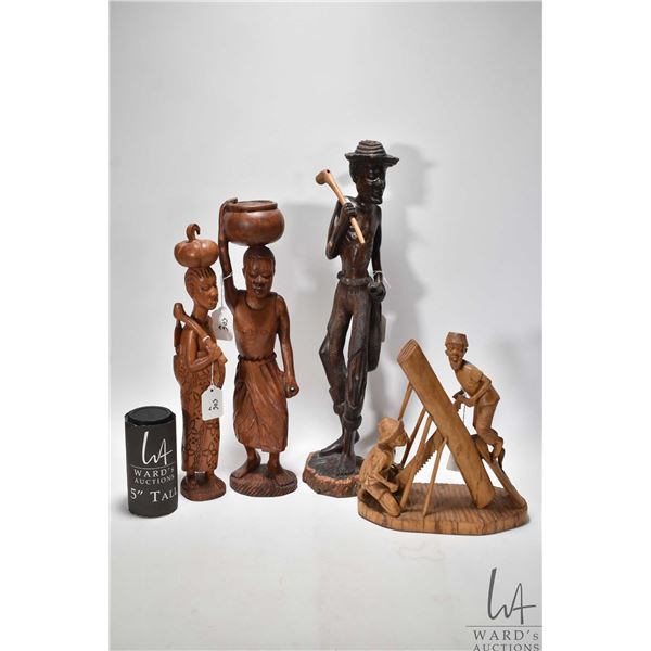 Four carved wooden figures including 20" man w/ club, 16" woman w/ basket, 15" woman w/ child and 10