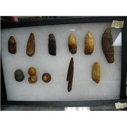 Lot of old artifacts including polar bear tooth, walrus teeth, harpoon, net weights, shaft straightn