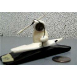 Carved ivory hunter in kayak with stone face mounted on baleen- baleen base is 4-3/4" x 1-1/2", figu