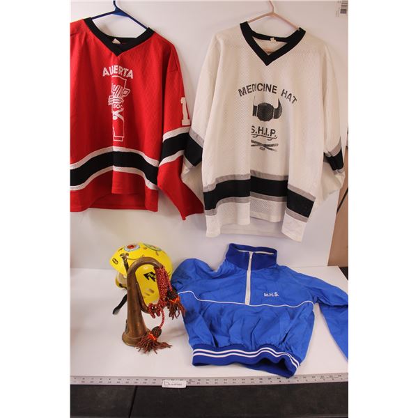 (2) Large Hockey shirts (Alberta/ M.H.S.), (1) XL Medicine Hat Jersey, Helmet, Brass Horn