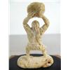 Image 3 : Bone carving of a cave man throwing a rock mounted on wood base ()