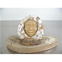 Man's face done out of fossilized ivory mounted on bone ()