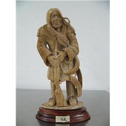 7-1/2" bone carving of a Native American with gun and cartridge belt and powder horn mounted on wood