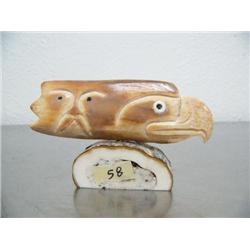 5" fossilized ivory eagle's head and man's face with inset baleen and ivory eyes mounted on fossiliz