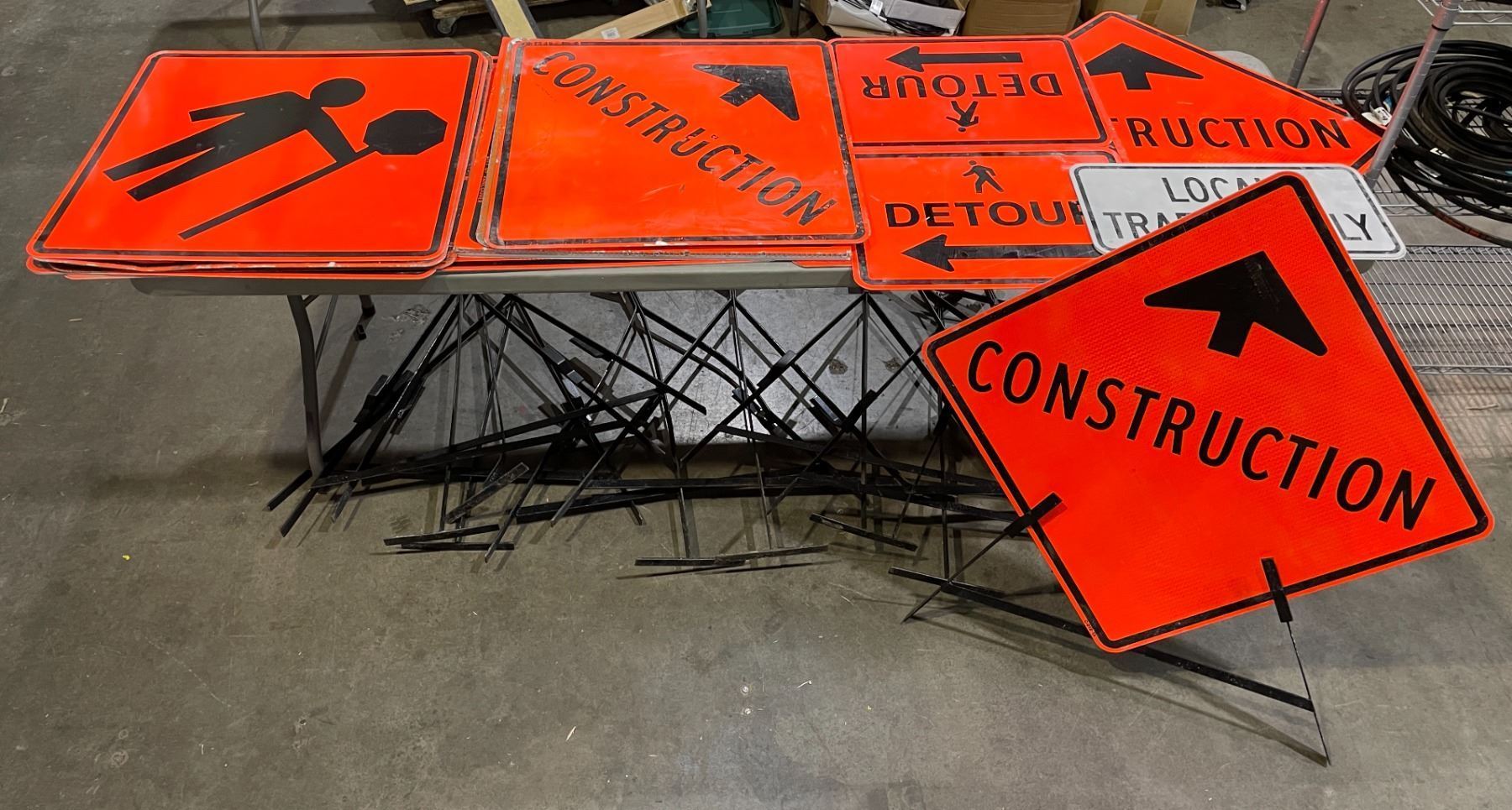 Large group of metal street construction signs with stands