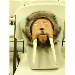 Walrus head carved into man's face with carved animal tusks, inset ivory eyes and driftwood pupils, 