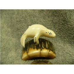 Carved ivory swimming seal mounted on fossilized ivory- 1-5/8" tall