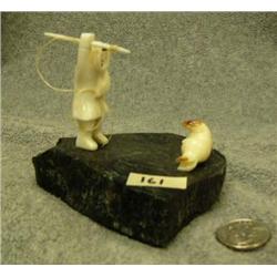 Carved ivory seal hunter and seal mounted on marble by G. Penatac