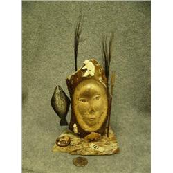 Relief carved bone face with carved ivory bear on forehead, carved bone salmon under chin, ivory car