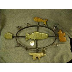 Soapstone salmon mask surrounded by soapstone whale, hand, bear, and wolf and also feathers by Inupi