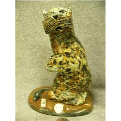 Soapstone otter on soapstone, with soapstone fish at feet and a carved ivory face 8-1/2" tall
