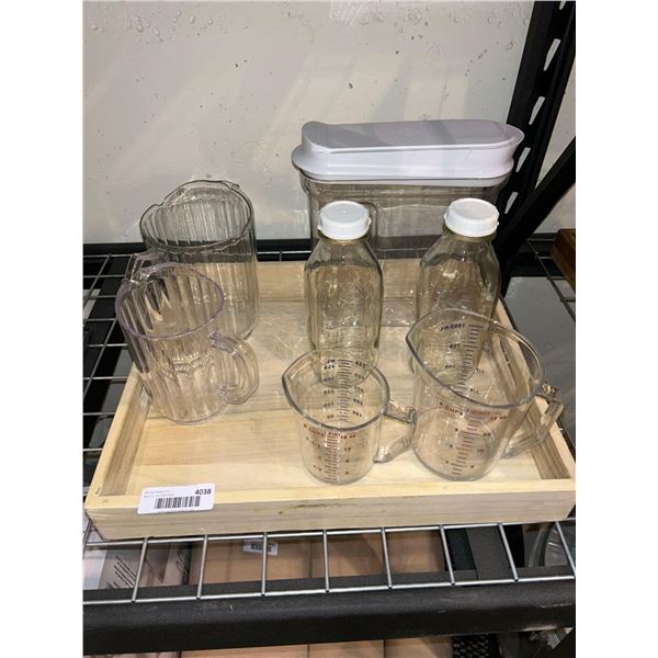 Lot of assorted kitchen items, measuring cups, drink jugs, glass bottles and storage container with 