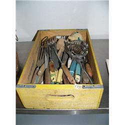 Old Pepsi box full of antique utensils with yellow and blue painted handles, and an African basket (