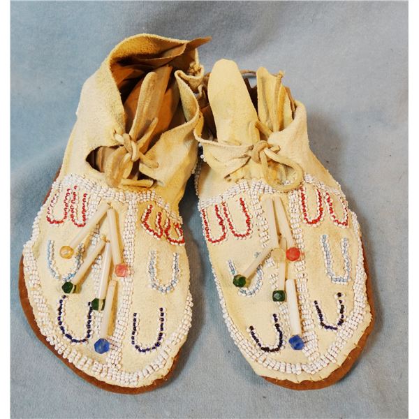 Child's beaded moccasins in display case