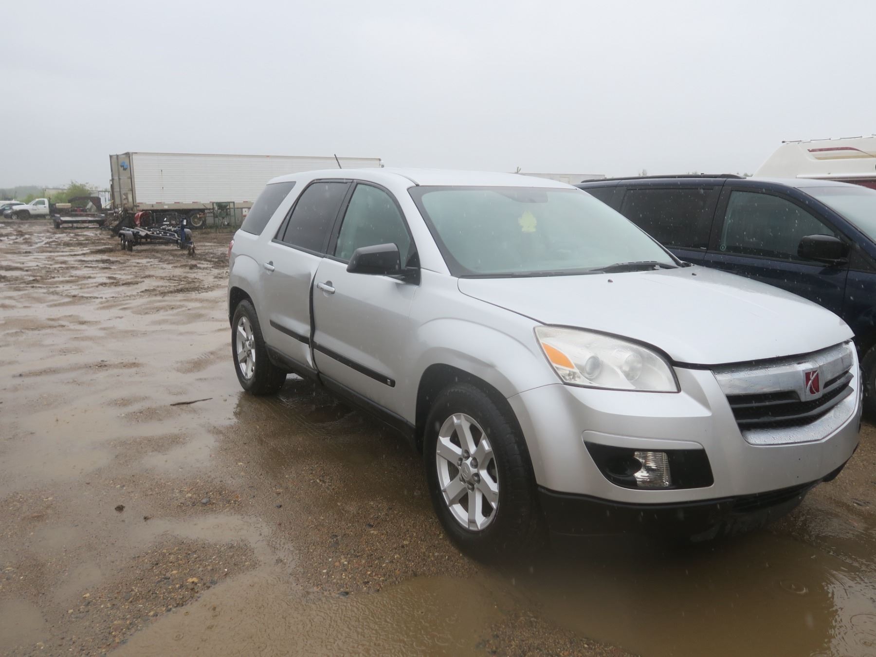 2009 Saturn Outlook with a roof rack and luggage carriers on top of the vehicle for extra storage space.