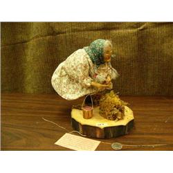 L. Huduran women picking berries with clay face and hands, basket full of red berries, stand 64 is a