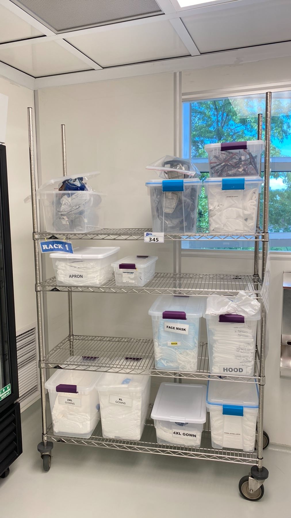 ULINE 4 TIER METAL MOBILE RACK WITH ASSORTED MASKS AND CLEANROOM GOWNS ...