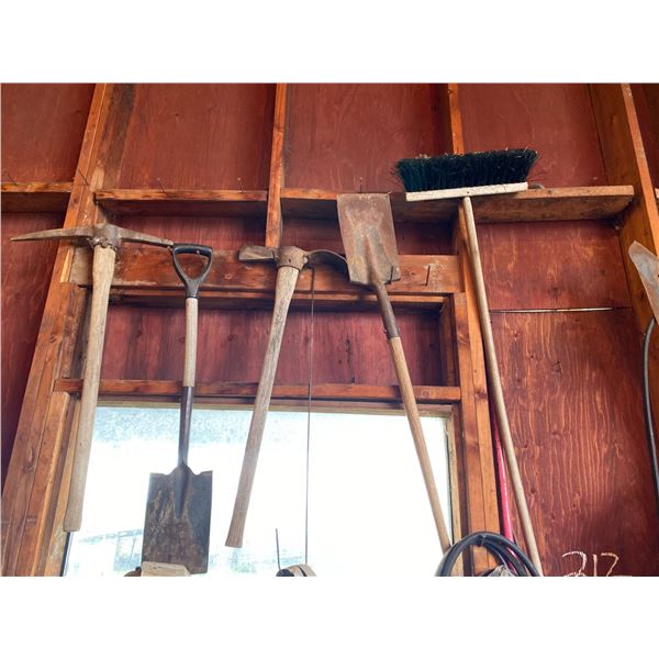 Misc. on east wall, steel, ladder, shovels, picks, brooms, cords.