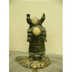Soapstone Eskimo with child on shoulders, both with ivory faces on soapstone base by  E.S. 3.75" tal