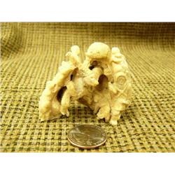 Carved ivory collage of bear, eagle, rams, wolf, 2 hunters, woman, and 6 faces- 2" tall (74)