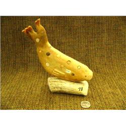 8" spotted seal carved from bone and mounted on antler base with inset ivory (25)